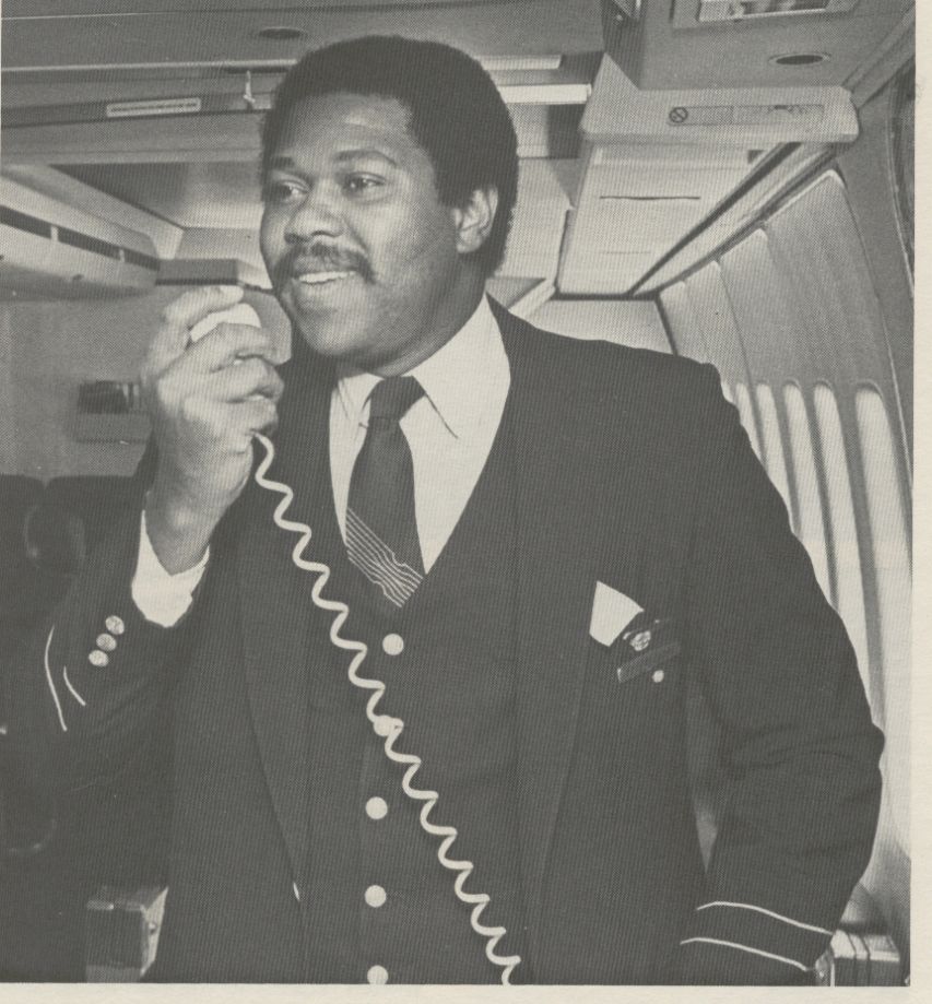 1981 Pan Am Purser Zachery Hobbs on the public address system in the first class cabin of a Boeing 747SP.